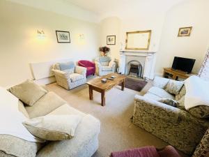 a living room with couches and a fireplace at Croxton House in Kirmington