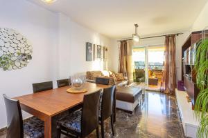 sala de estar con mesa de madera y sillas en Sunset Apartment Fuengirola, en Fuengirola
