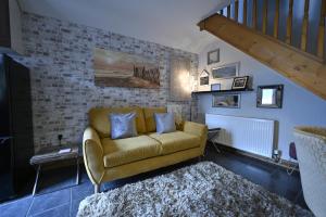 a living room with a couch and a staircase at The Mews @ The Pheasant in Ironbridge