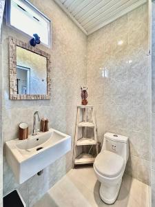 La salle de bains est pourvue d'un lavabo, de toilettes et d'un miroir. dans l'établissement Guest house Star No.1, à Bedahulu