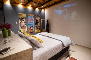 - un lit dans une chambre avec des affiches sur le mur dans l'établissement Cabana com Ofurô e Cinema a 6km do Centro, à Ibicaré