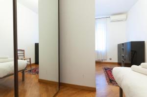 Habitación con 2 camas y espejo. en Casa Leonardo Da Vinci - 10 minuti dal Duomo en Milán