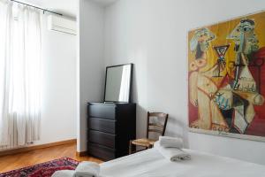 1 dormitorio con 1 cama y una pintura en la pared en Casa Leonardo Da Vinci - 10 minuti dal Duomo en Milán