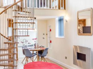 a living room with a table and chairs and a spiral staircase at 2 bed in Ellesmere 62544 in Ellesmere