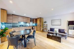 uma cozinha e sala de estar com uma mesa e um sofá em Stunning 2 Bed Apartment with view of the Shard em Londres