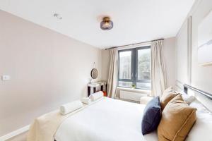 um quarto branco com uma cama grande e uma janela em Stunning 2 Bed Apartment with view of the Shard em Londres
