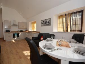 a dining room and kitchen with a white table and chairs at 2 bed property in Bath 72837 in Chew Magna