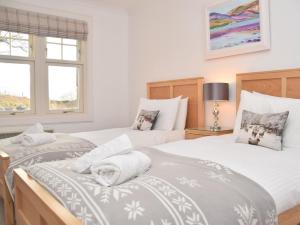 two twin beds in a room with two windows at 5 bed in Colintraive 74117 in Colintraive