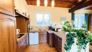 a kitchen with wooden cabinets and a white refrigerator at Villa au calme à proximité de la mer in La Couarde-sur-Mer +3 photos