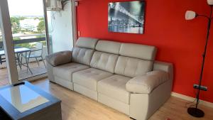 a living room with a white couch and a red wall at Apartamento Ginette SunBeach in Salou
