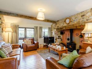 a living room with leather furniture and a fireplace at 3 Bed in Coombe Keynes DC029 in Wool