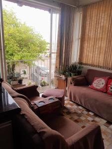 un soggiorno con divano e una grande finestra di Casa e Ateliê de pintura Neiva Mario a São Gabriel