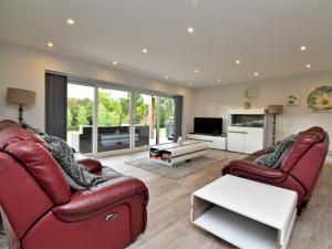 a living room with two red chairs and a tv at 4 bed in Oswestry 73291 in Kinnerley