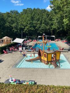 a pool with a pirate ship in a playground at Holiday park Duinhoeve in Udenhout