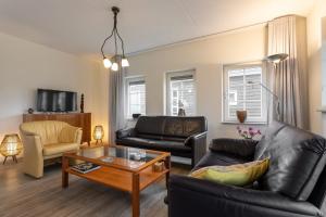 a living room with a couch and a coffee table at Hello Zeeland - Vakantiewoning Knuitershoek 104 