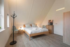 a bedroom with a bed and a dresser in it at Hello Zeeland - Vakantiewoning Knuitershoek 104 