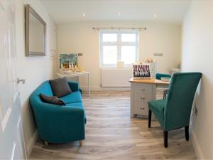 sala de estar con silla azul y escritorio en 2 Bed in Mundesley KT152 en Mundesley