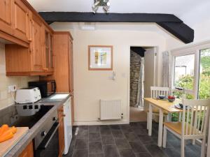 a kitchen with wooden cabinets and a table and a table sidx sidx sidx at 1 Bed in Wolsingham 36674 in Wolsingham