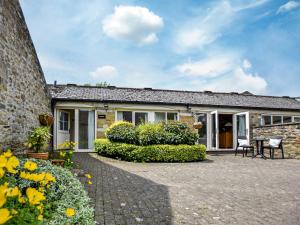 a stone house with a patio and flowers at 1 Bed in Wolsingham 36674 in Wolsingham