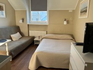 ein kleines Zimmer mit 2 Betten und einem Sofa in der Unterkunft Gedimino House in Vilnius