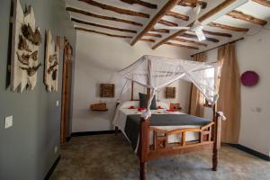MakunduchiにあるNest Style Beach Hotel Zanzibarのベッドルーム(天蓋付きベッド1台付)