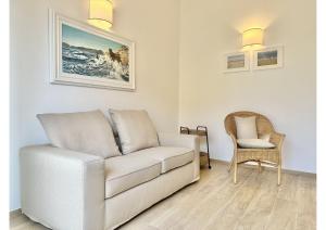een woonkamer met een witte bank en een stoel bij (3 suites in the sea) luxe apartment in Camaiore