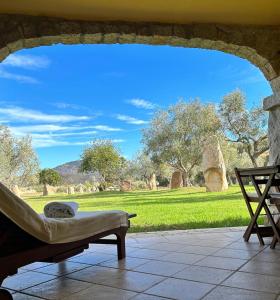 un banco sentado en un patio con vistas a un campo en Hotel I Menhirs, en Annunziata