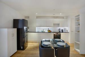 a kitchen with a table and a black refrigerator at Lovely Spacious Central Croydon Apartment in Croydon