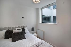 Lovely Spacious Central Croydon Apartment في كرويدون: غرفة نوم بيضاء بها سرير ونافذة