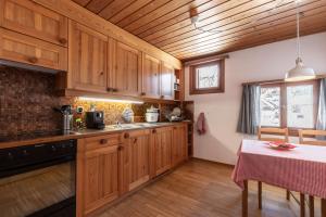 una cocina con armarios de madera y una mesa con mantel. en Chasa Curasch, en Scuol