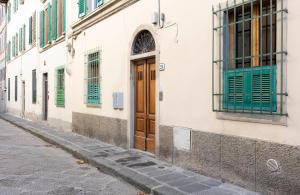 a building with green shutters and a wooden door at Santa Croce Comfort Apartment in Florence