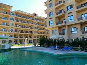 a swimming pool in front of a building at Comfort Zone at Turtles Beach Resort in Hurghada