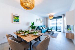 a dining room and living room with a table and chairs at Apartament Flamenca Village Lime & Lemon in Orihuela Costa