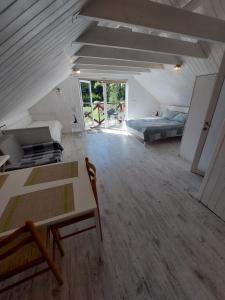 a attic room with a bed and a desk and a bed at Apartamenti pie jūras 5 cilvēkiem, otrā stāvā in Plieņciems