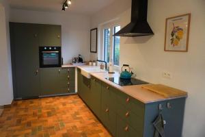eine Küche mit grünen Schränken und einer Arbeitsplatte in der Unterkunft Chez Joséphine in Huy
