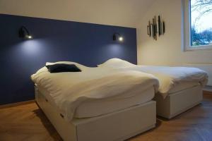 a large white bed in a bedroom with a blue wall at Chez Joséphine in Huy