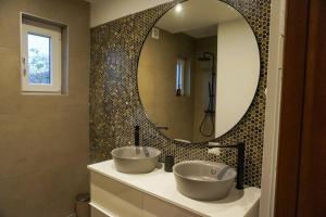 a bathroom with two sinks and a large mirror at Chez Joséphine in Huy