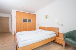 - une chambre avec un lit et un canapé vert dans l'établissement Apartment Edelweiss, à Brunico
