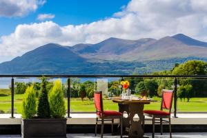 a patio with a table and chairs and mountains at Castlerosse Park Resort in Killarney
