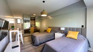 een slaapkamer met twee bedden en een spiegel bij Soho Rentals in Buenos Aires