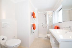 a white bathroom with a toilet and a sink at Apartment Edelweiss in Brunico +41 photos
