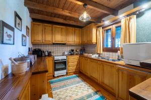 a kitchen with wooden cabinets and a sink and a stove at Dandy on the hill Chalet Artemis - Fir Forest - Jeep & Nature Lovers in Eptalofos