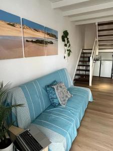eine blaue Couch in einem Wohnzimmer mit Laptop darauf in der Unterkunft Casa Cactus Paraiso in Parque Holandes