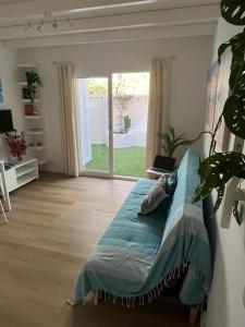 ein Wohnzimmer mit einem Sofa und einem großen Fenster in der Unterkunft Casa Cactus Paraiso in Parque Holandes