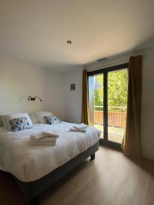 a bedroom with a bed and a large window at Gite Lomegaja 6pers proche Lascaux et Sarlat in La Chapelle-Aubareil