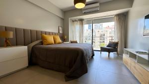 a bedroom with a bed and a chair and a window at Soho Rentals in Buenos Aires