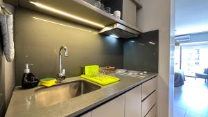 cocina con fregadero y estante para platos amarillos en Soho Rentals en Buenos Aires