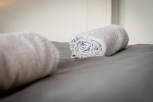 a roll of towels sitting on top of a bed at Le Studio by La Reine City Center in Spa