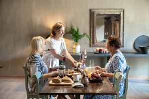 tres mujeres sentadas alrededor de una mesa con comida en 15 inn, en Mol