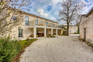 an old stone house with a balcony on a driveway at Holiday House Orbanic in Modrušani